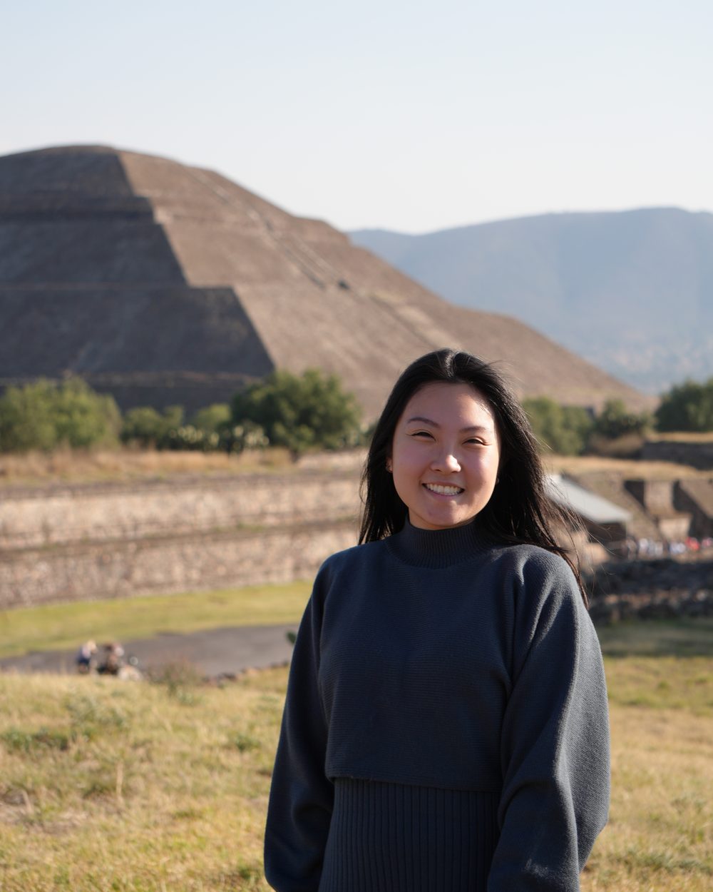 Tiemy Higa sorrindo, com a Pirâmide do Sol de Teotihuacan ao fundo